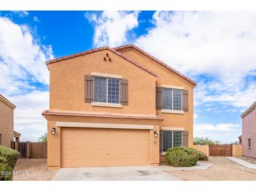 Two-story home featuring a two-car garage, landscaped yard, and inviting curb appeal at 18774 N Ibis Way, Maricopa, AZ 85138