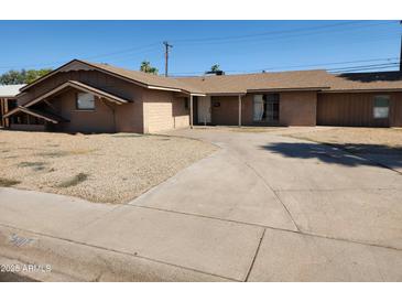 Single story home showcasing its desert landscaping, a long driveway and front facade at 6017 W Colter St, Glendale, AZ 85301