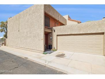 Beige two-story home featuring an attached two car garage, and a neutral desert landscape at 7756 N 19Th Ln, Phoenix, AZ 85021