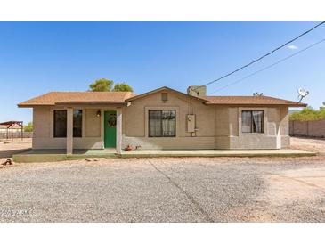 Charming single-story home with a brown roof, green door, and a spacious gravel front yard at 44446 N 14Th St, New River, AZ 85087