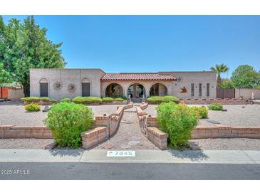 Charming single-story home featuring a brick exterior, arched entryways, and desert landscaping at 7645 W Bluefield Ave, Glendale, AZ 85308