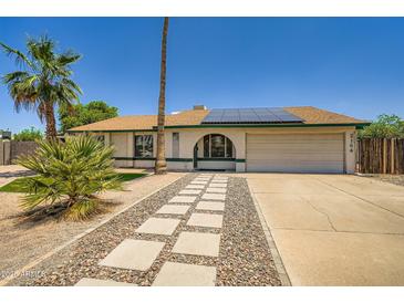 Charming single-Gathering home featuring desert landscaping, a two car garage, and solar panels at 2164 E Jerome Ave, Mesa, AZ 85204
