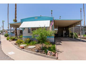 Charming manufactured home featuring a carport, manicured landscaping, and a welcoming curb appeal at 4065 E University Dr # 76, Mesa, AZ 85205