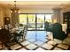 Open-concept dining and living area with pool view, elegant chandelier, and modern decor for seamless entertaining and relaxation at 12797 S 179Th Dr, Goodyear, AZ 85338