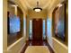 Inviting entryway with a grand wooden door, side windows, decorative lighting, and artwork, setting a sophisticated tone for the home at 12797 S 179Th Dr, Goodyear, AZ 85338