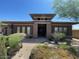 Stylish front entrance featuring stone pillars, desert landscaping, and a gated walkway at 12797 S 179Th Dr, Goodyear, AZ 85338