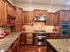 Spacious kitchen featuring custom cabinets, granite countertops, and stainless-steel appliances for both functionality and style at 12797 S 179Th Dr, Goodyear, AZ 85338