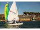 A sailboat floats on the calm lake against a backdrop of palm trees at 12797 S 179Th Dr, Goodyear, AZ 85338