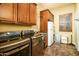 Functional laundry room with modern washer and dryer, utility sink, and storage cabinets at 12797 S 179Th Dr, Goodyear, AZ 85338
