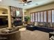 Inviting living room featuring a stone fireplace, plush sofa, and natural light at 12797 S 179Th Dr, Goodyear, AZ 85338