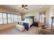 Large main bedroom with plantation shutters, sitting area, and ceiling fan at 12797 S 179Th Dr, Goodyear, AZ 85338