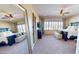 Spacious main bedroom features a large bed, plush carpet, and large windows offering views at 12797 S 179Th Dr, Goodyear, AZ 85338