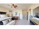 Large main bedroom showcasing a cozy seating area, ceiling fan, and window shutters at 12797 S 179Th Dr, Goodyear, AZ 85338