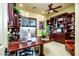 Spacious home office featuring custom wood built-ins, a ceiling fan, and a large wooden desk at 12797 S 179Th Dr, Goodyear, AZ 85338