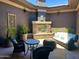 Relaxing outdoor patio space with stone fireplace, comfortable seating, and a charming ambiance for entertaining and leisure at 12797 S 179Th Dr, Goodyear, AZ 85338