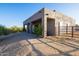 Tan stucco barn with covered patio and metal fencing at 14021 E Milton Ct, Scottsdale, AZ 85262