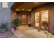 Inviting entryway with double wooden doors and lush potted plants at 14021 E Milton Ct, Scottsdale, AZ 85262