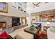Spacious living room features a stone fireplace, high ceilings, and a view into the kitchen at 14021 E Milton Ct, Scottsdale, AZ 85262