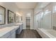 This bathroom features a double vanity, glass enclosed shower, and walk-in closet at 578 E Las Puertas Ln, Queen Creek, AZ 85140