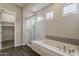 This modern bathroom features a glass shower, soaking tub, and neutral finishes at 578 E Las Puertas Ln, Queen Creek, AZ 85140