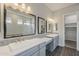 Bathroom with double sinks, quartz countertops, framed mirrors, and wood-look floors at 578 E Las Puertas Ln, Queen Creek, AZ 85140