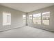Bright bedroom with neutral carpet, walls, and large windows with neighborhood views at 578 E Las Puertas Ln, Queen Creek, AZ 85140