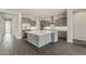 Bright, open kitchen with a large center island, stainless steel appliances, and stylish gray cabinetry at 578 E Las Puertas Ln, Queen Creek, AZ 85140