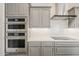 Gourmet kitchen with stainless steel appliances, double ovens, sleek cabinetry, and a modern range hood at 578 E Las Puertas Ln, Queen Creek, AZ 85140