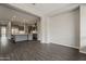 Open living room with wood floors flowing into kitchen with large island and stainless steel appliances at 578 E Las Puertas Ln, Queen Creek, AZ 85140