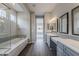 Luxurious main bathroom with wood look floors, double vanity, large soaking tub and separate shower at 578 E Las Puertas Ln, Queen Creek, AZ 85140