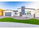 Contemporary home showcasing its manicured lawn, stone accents, and neutral colors at 7583 W Gelding Dr, Peoria, AZ 85381