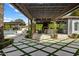 A luxurious outdoor living space with a pergola, outdoor kitchen, bar, TV, fireplace, and travertine tile at 7533 N 70Th St, Paradise Valley, AZ 85253