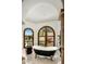 Luxurious bathroom with a freestanding tub, arched windows, and natural light at 7533 N 70Th St, Paradise Valley, AZ 85253