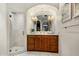 Bathroom with marble shower, wood cabinets, large mirror, and views of the outdoors at 7533 N 70Th St, Paradise Valley, AZ 85253