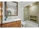 Bathroom with a shower and tub combination, tiled shower, and wooden vanity with a stone countertop at 7533 N 70Th St, Paradise Valley, AZ 85253