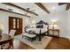 Bedroom with wood-beamed ceiling, ceiling fan, and access to an outdoor patio with stunning arched door at 7533 N 70Th St, Paradise Valley, AZ 85253
