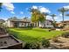 Expansive exterior featuring a lush lawn, mature trees, a fire pit, and a large, luxurious home at 7533 N 70Th St, Paradise Valley, AZ 85253