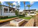 Outdoor fire pit with seating, an outdoor kitchen, and a view of the main house and desert landscaping at 7533 N 70Th St, Paradise Valley, AZ 85253