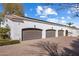 Spacious four-car garage, set behind a beautiful white home with a red tile roof and lush landscaping at 7533 N 70Th St, Paradise Valley, AZ 85253