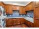 Well-appointed laundry room with custom wood cabinets, granite counters, and a farmhouse sink with tile backsplash at 7533 N 70Th St, Paradise Valley, AZ 85253