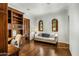 Sitting room with wood floor, wood built-ins, a cream sofa, arched windows, and a small table at 7533 N 70Th St, Paradise Valley, AZ 85253