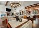 Spacious open-concept kitchen, dining, and living area with hardwood floors, a stone fireplace and chandeliers at 7533 N 70Th St, Paradise Valley, AZ 85253