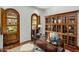 Home office featuring a large wooden desk, built-in bookcase and natural light with wooden doors at 7533 N 70Th St, Paradise Valley, AZ 85253