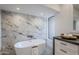 Relaxing bathroom with freestanding bathtub and marble feature wall at 41327 N 106Th St, Scottsdale, AZ 85262