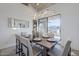 Modern dining room with a wooden table, light beige chairs, and large windows at 41327 N 106Th St, Scottsdale, AZ 85262