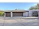 Three-car garage with brown doors and a spacious driveway at 41327 N 106Th St, Scottsdale, AZ 85262