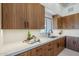 Modern kitchen with wood cabinets, quartz countertops and a farmhouse sink at 41327 N 106Th St, Scottsdale, AZ 85262