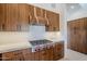 Modern kitchen features wood cabinets, quartz countertops and a gas cooktop at 41327 N 106Th St, Scottsdale, AZ 85262
