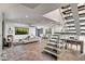 Open concept living space with glass staircase, fireplace, and modern furnishings at 8094 E Via Del Vencino --, Scottsdale, AZ 85258