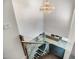 Modern staircase with glass railings and a decorative chandelier above landing with a partial kitchen view at 8094 E Via Del Vencino --, Scottsdale, AZ 85258